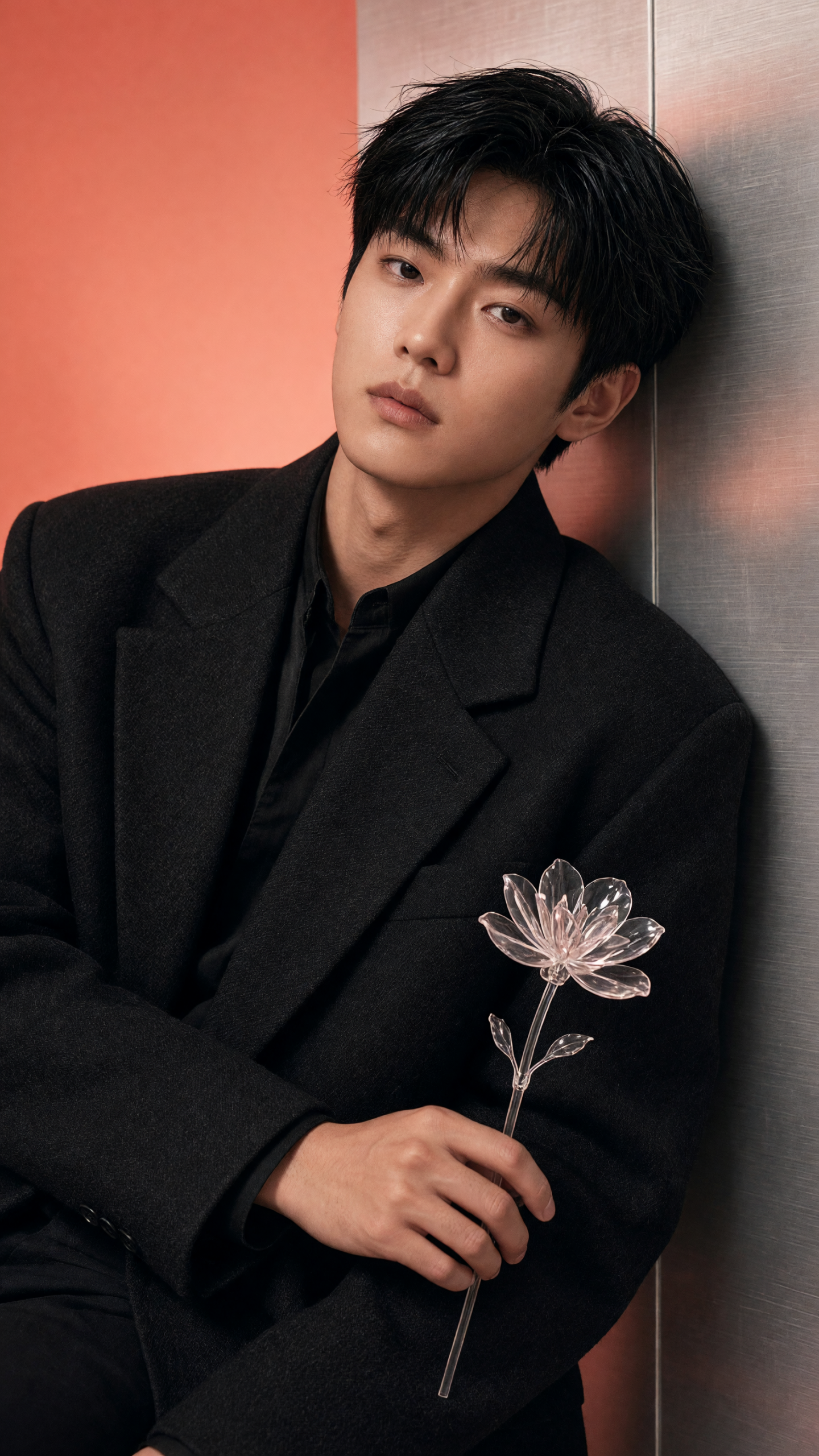 Editorial menswear portrait against a coral studio wall