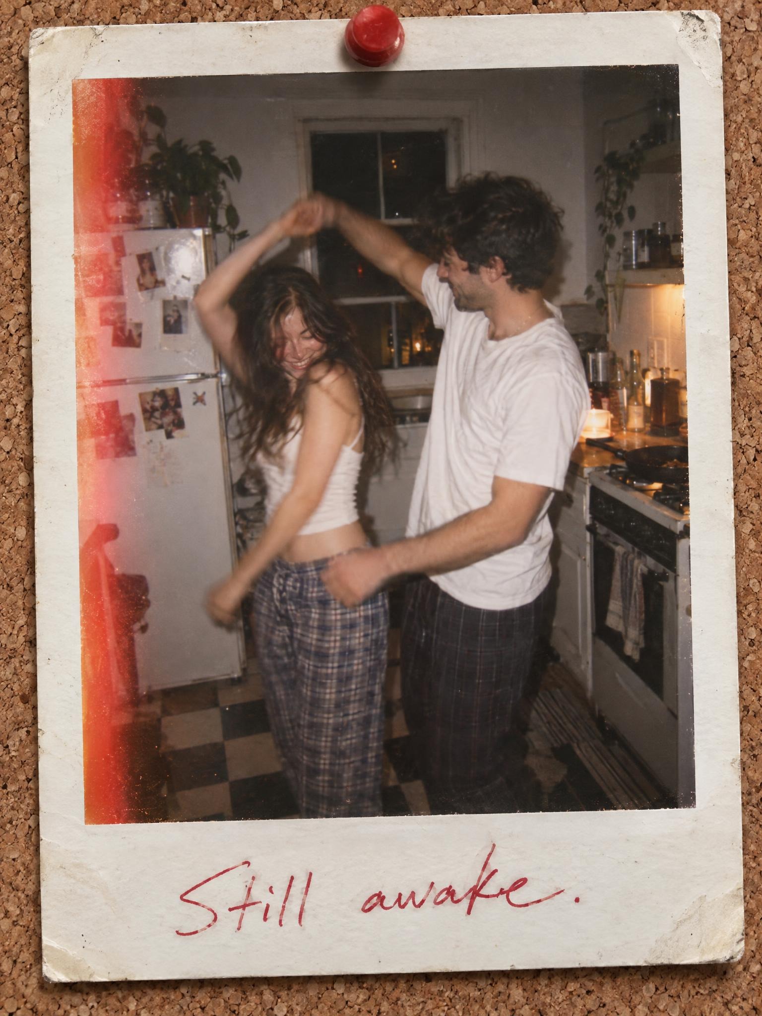 Fictional couple dancing in a kitchen rendered as an instant-film print